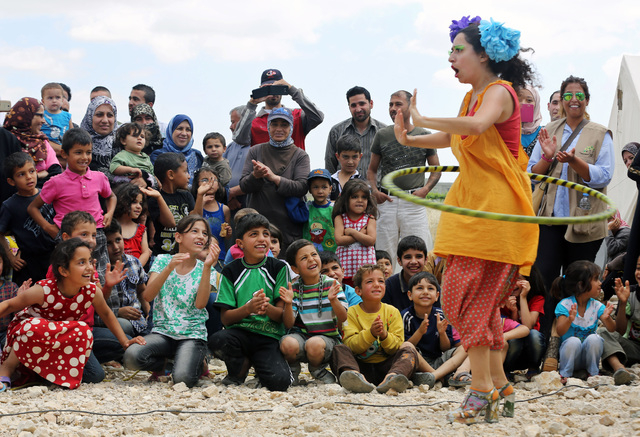 In this June 6, 2014 photo, Lebanese clown Sabine Choucair, a ?member of "Clowns Without Borders," performs for children at a Syrian refugee camp in the eastern town of Chtoura, in Bekaa ...