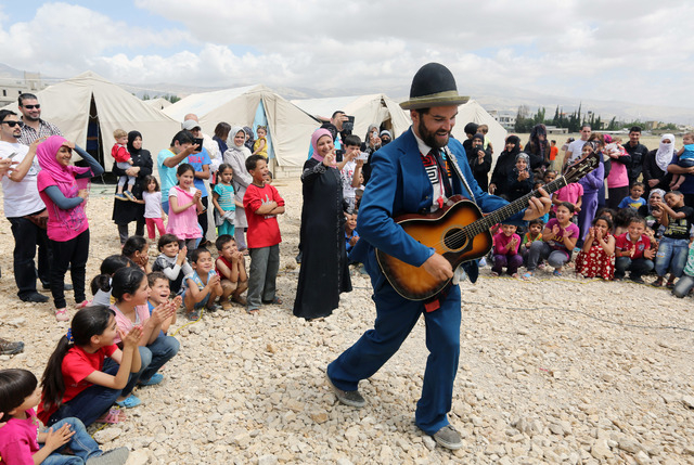 In this June 6, 2014 photo, American clown David Clay, a member of "Clowns Without Borders," performs for children at a Syrian refugee camp in the eastern town of Chtoura, in Bekaa valle ...