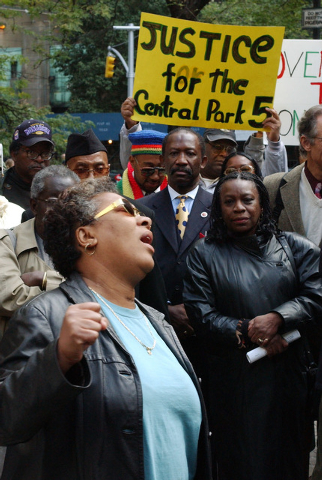In this Oct. 21, 2002 file photo, Dolores Wise, left, whose son Kharey Wise was one of five youths convicted in the 1989 Central Park jogger case, pumps her fist in the air as she sings "We Shall ...