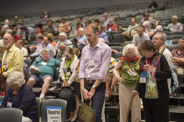 The audience takes part in an opening prayer at the 221st General Assembly of the Presbyterian Church at Cobo Hall, in Detroit, Thursday, June 19, 2014. The top legislative body of the Presbyteria ...