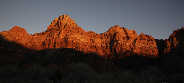 Shadows creep up on sandstone cliffs glowing red as the sun sets on Zion National Park near Springdale, Utah. The National Park Service is taking steps to ban drones from 84 million acres of publi ...