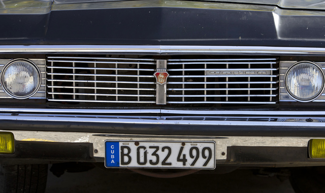 In this June 18, 2014 photo, a Soviet-made limousine taxi cab sits parked in Havana, Cuba. In a former life they were the "comandante's" cars: A fleet of black, boxy, Soviet-made limousines that f ...