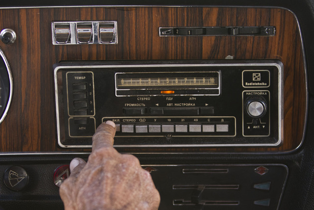 In this June 18, 2014 photo, taxi driver Moises Suarez turns on the radio inside the Soviet-made limousine taxi cab that once belonged to Fidel Castro's fleet which he rents from the government in ...