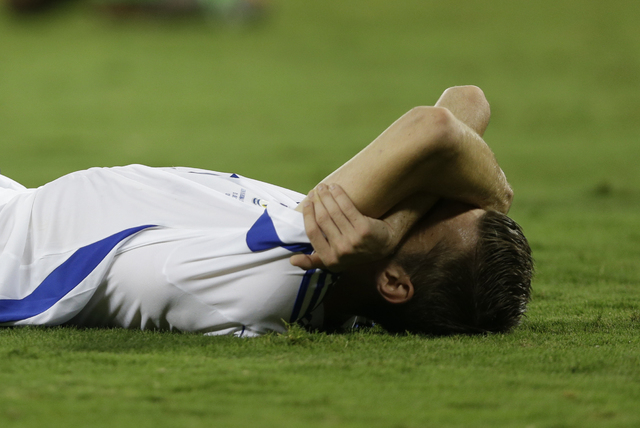 Bosnia's Tino-Sven Susic lies on the pitch with his arms over his face after the end of the group F World Cup soccer match between Nigeria and Bosnia at the Arena Pantanal in Cuiaba, Brazil, Satur ...