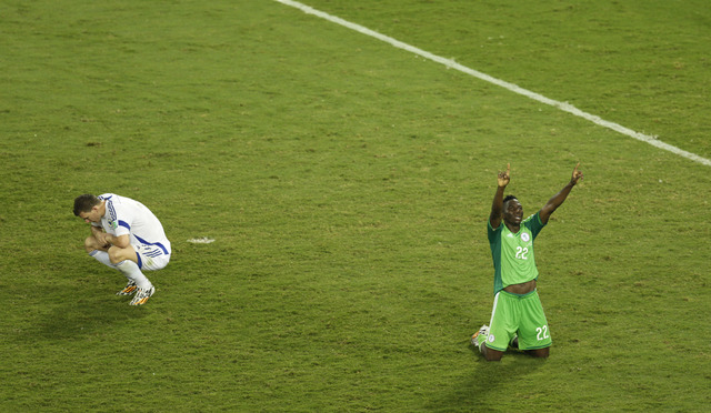 Nigeria's Kenneth Omeruo, right, celebrates as Bosnia's Edin Dzeko, left, sits on the pitch after the group F World Cup soccer match between Nigeria and Bosnia at the Arena Pantanal in Cuiaba, Bra ...