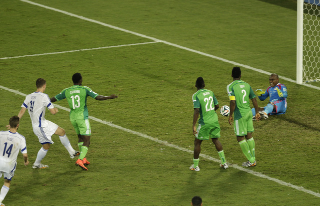 Nigeria's goalkeeper Vincent Enyeama, right, blocks a shot by Bosnia's Edin Dzeko, left, during the group F World Cup soccer match between Nigeria and Bosnia at the Arena Pantanal in Cuiaba, Brazi ...