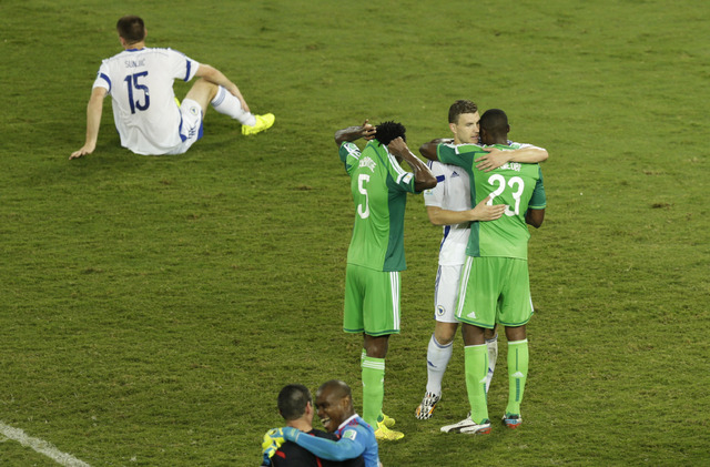 Bosnia's Edin Dzeko, second right, hugs Nigeria players after the group F World Cup soccer match between Nigeria and Bosnia at the Arena Pantanal in Cuiaba, Brazil, Saturday, June 21, 2014. Nigeri ...