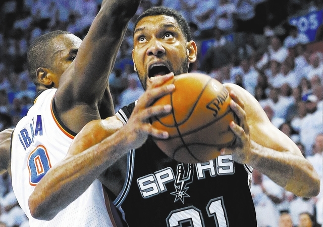 San Antonio Spurs forward Tim Duncan (21) shoots against Oklahoma City Thunder forward Serge Ibaka in overtime of Game 6 of the Western Conference finals NBA basketball playoff series in Oklahoma  ...