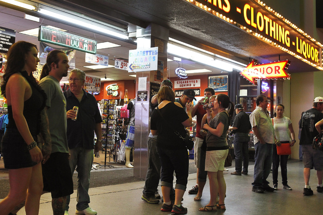 People hangout with their drinks that they purchased from a convenience shop at the Fremont Street Experience in Las Vegas on Thursday, May 22, 2014. Las Vegas City Council approved a liquor ordin ...