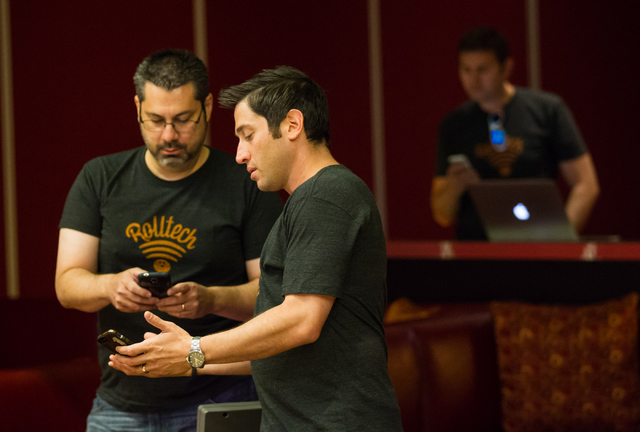 Rolltech CTO Rick Duggan, left, talks with founder and CEO Rich Belsky as the company runs tests for their bowling app. (Chase Stevens/Las Vegas Review-Journal)
