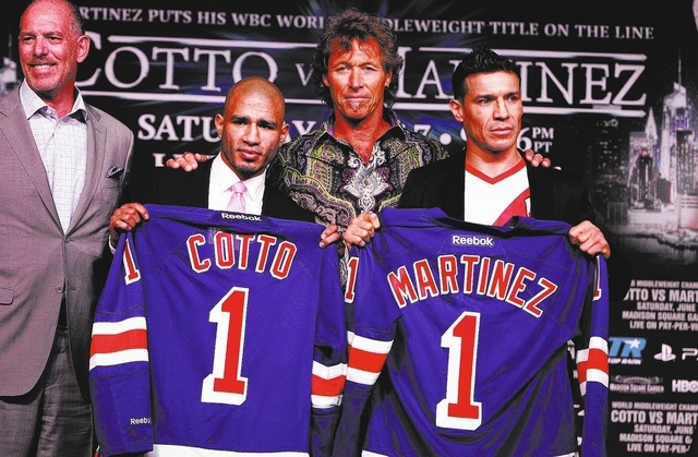 Former New York Rangers player Ron Duguay, center, and Madison Square Garden executive vice president Joel Fisher, left, present Rangers jerseys to former world champion Miguel Cotto and WBC world ...