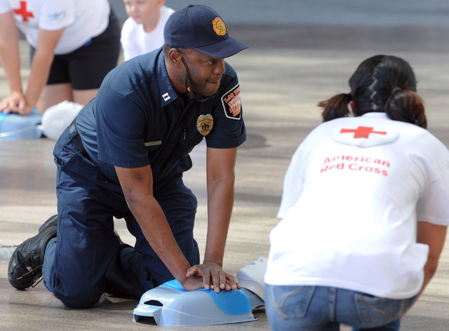 Las Vegas Fire Department Captain Lionel Newby performs CPR on a manikin front of the Third Street stage at Fremont Street Experience in downtown Las Vegas, Friday, June 6, 2014. In a flash mob ex ...