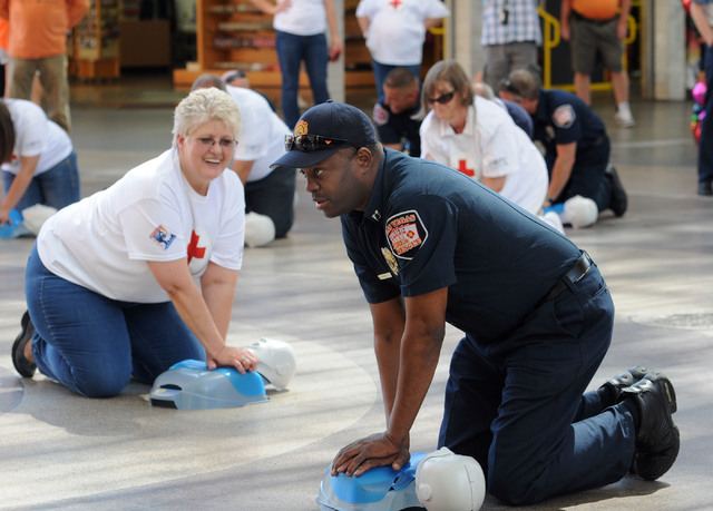 Las Vegas Fire Department Captain Lionel Newby performs CPR on a manikin front of the Third Street stage at Fremont Street Experience in downtown Las Vegas, Friday, June 6, 2014.  In a flash mob e ...