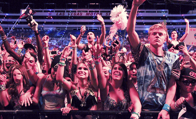 Attendees react as Diplo performs at the Cosmic Meadow stage at the Electric Daisy Carnival at the Las Vegas Motor Speedway in Las Vegas during the early hours of Saturday, June 21, 2014. (Chase S ...