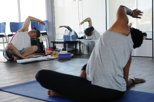 Steven Michael, left, takes directions from yoga instructor Chidimma Ozor during a class at Turntable Health, June 9. (Erik Verduzco/View)