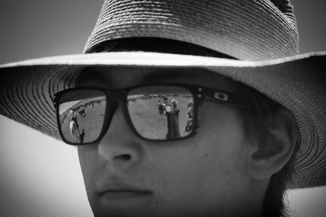 Cattle branding reflect off Erik Jackson, 19, glasses  at the Twin Creek Ranch, located about 200 miles north of Las Vegas as seen Wednesday, June 4, 2014. The Fallini family has been operating th ...