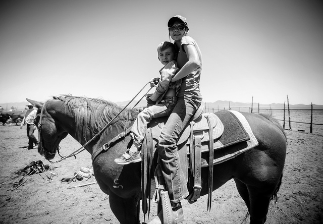 Giovanni Berg, 6, left, and his cousin Rheanna Jackson,14  during branding at the family's Twin Creek Ranch, located around 200 miles north of Las Vegas on Wednesday, June 4, 2014. The Fallini fam ...