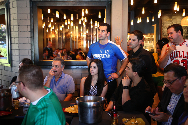 State Sen. Ruben Kihuen, D-Las Vegas, center, watches the game during his "Soccer with the Senator" event for supporters featuring a watch party for the Mexico vs. Brazil World Cup game ...