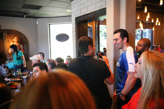State Sen. Ruben Kihuen, D-Las Vegas, right, in blue, mingles with the crowd during his "Soccer with the Senator" event for supporters featuring a watch party for the Mexico vs. Brazil W ...