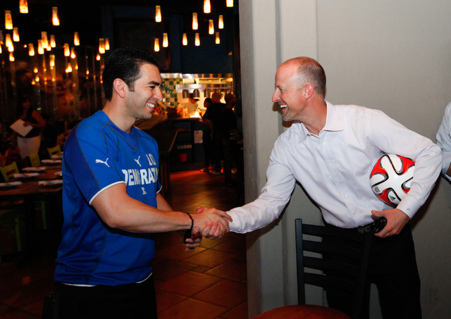 State Sen. Ruben Kihuen, D-Las Vegas, left, greets Justin Findlay during Kihuen's "Soccer with the Senator" event for supporters featuring a watch party for the Mexico vs. Brazil World C ...