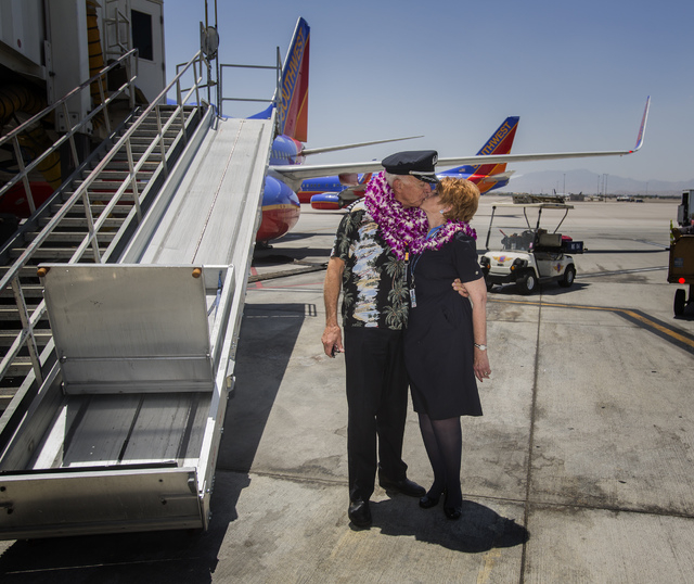 Southwest Airline  pilot Capt. Fred Sorenson,left, kisses head flight attendant Pat Schader on the tarmac  at  McCarran International Airport after making his final flight with the airlines on Wed ...