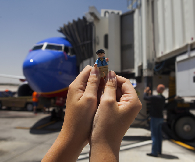 Jeremy Stanton, 10, holds a LEGO Indiana Jones  Jock character in front of a  Southwest Airline flown by Capt. Fred Sorenson at  McCarran International Airport on Wednesday, June 11 , 2014. Sorens ...