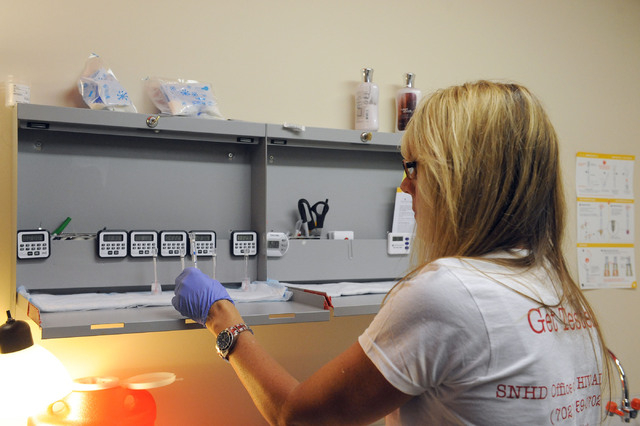 Cherie Fillen-Maietta, a disease investigator with the Southern Nevada Health District, checks an HIV testing kit at The Center, 401 S. Maryland Parkway, in Las Vegas, Thursday, June 12, 2014. (Je ...