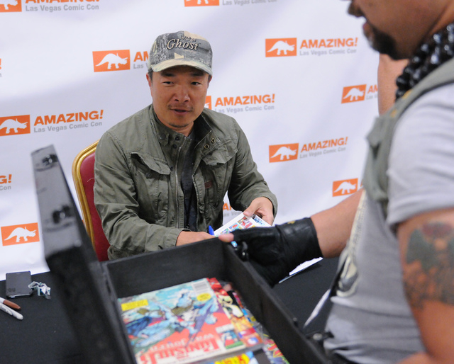 Comic book illustrator and publisher Jim Lee greets a fan waiting to get his autograph during the 2014 Amazing Las Vegas Comic Con at South Point casino-hotel in Las Vegas Saturday, June 21, 2014. ...
