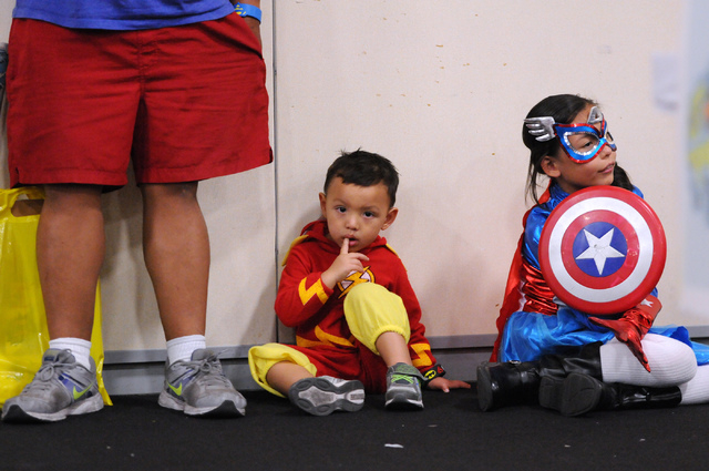 Joe Bernardo, from left, his son Kai, 3, in character as the Flash, and his daughter Leilani, 11, in character as Captain America, take a break during the 2014 Amazing Las Vegas Comic Con at South ...