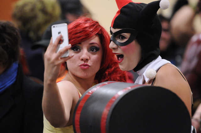Jenny Egidio, left, in character as Misty from Pokémon, and her friend Miranda Cooper, in character as Harley Quinn, take a photo together as they wait line to participate in the costume cont ...