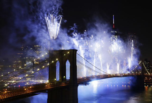 Fireworks light up the sky above the Brooklyn Bridge during the Macy's Annual Fourth of July fireworks show, Friday, July 4, 2014, in New York. (AP Photo/Mark Lennihan)