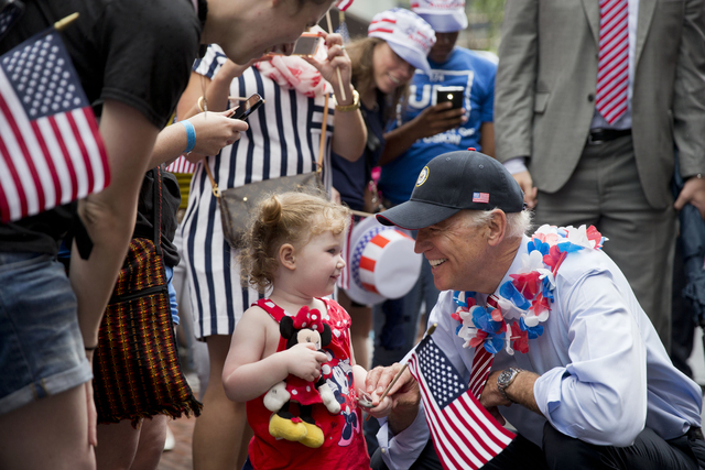 Vice President Joe Biden greets a young spectator as he marches in an Independence Day parade, Friday, July 4, 2014, at Independence Hall in Philadelphia. (AP Photo/Matt Rourke)