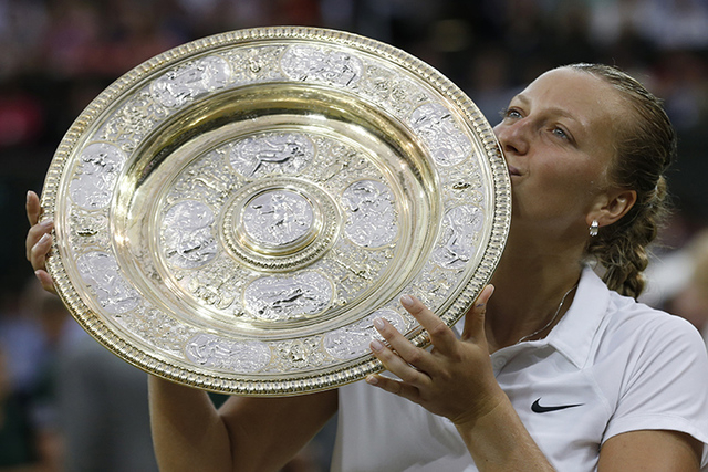 Petra Kvitova of Czech Republic kisses the trophy after winning the women's singles final against Eugenie Bouchard of Canada at the All England Lawn Tennis Championships in Wimbledon, London, Satu ...