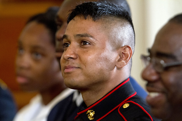 Marine Private First Class Oscar Gonzalez, who was born in Guatemala, listens as President Barack Obama speaks during a naturalization ceremony for active duty service members, including Gonzalez, ...