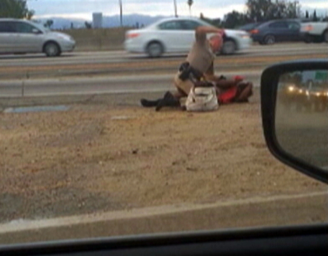 In this July 1, 2014 image made from video provided by motorist David Diaz, a California Highway Patrol officer straddles a woman while punching her in the head on the shoulder of a Los Angeles fr ...