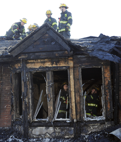 Philadelphia firefighters work on  burned row homes on Saturday, July 5, 2014, in Philadelphia. Authorities say the fast-moving fire early Saturday has killed four children. Fire department offici ...