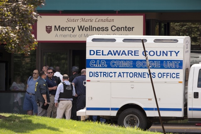 Investigators work the scene of a shooting Thursday, July 24, 2014, at Mercy Fitzgerald Hospital in Darby, Pa. A shooting at the suburban Philadelphia hospital campus has killed one worker and inj ...
