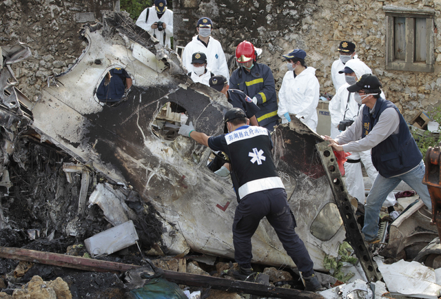 A forensic team recovers human remains among the wreckage of crashed TransAsia Airways flight GE222 on the outlying island of Penghu, Taiwan, Thursday, July 24, 2014. Stormy weather on the trailin ...