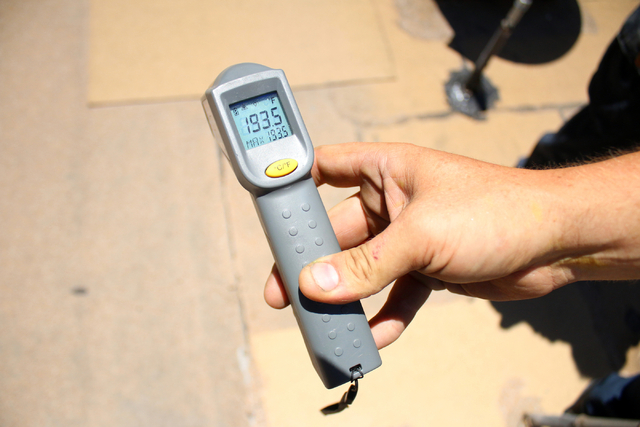 Air conditioner repairman, Peter Almanza of Cal Air tests the surface temperature on the roof of Planet Hollywood Miracle Mile Shops on Tuesday, July 1, 2014. Almanza and his partner performed mai ...