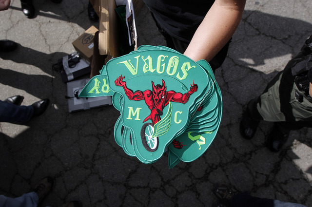 A police officer shows the Vagos motorcycle gang patches confiscated in a raid at a command post in San Bernardino, Calif., Thursday, Oct. 6, 2011. Hundreds of law enforcement officers have fanned ...