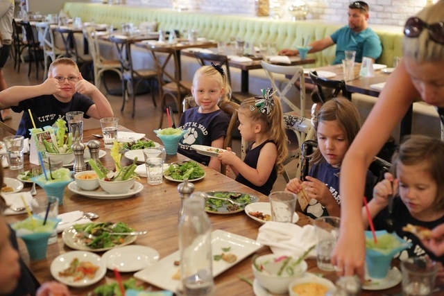 Students from Kitty Ward Elementary School sample items created with garden ingredients, June 30. (Special to View)
