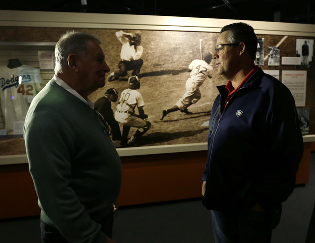 Former Atlanta Braves manager Bobby Cox, left, and former pitcher Greg Maddux visit a Jackie Robinson exhibit during their orientation visit at the Baseball Hall of Fame on Monday, March 24, 2014, ...
