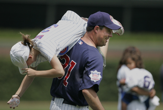 Chicago Cubs piitcher Greg Maddux plays with his daugher Paige during Cubs' Family Day before a baseball game against the Detroit Tigers, Saturday, June 17, 2006, in Chicago. (AP Photo/M. Spencer  ...