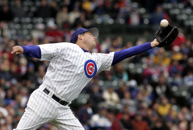 Chicago Cubs pitcher Greg Maddux stretches out to grab a grounder that bounced in the air hit by San Diego Padres' Adrian Gonzalez during the second inning of a baseball game Saturday, May 13, 200 ...