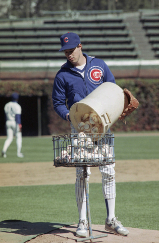 Chicago Cubs starting pitcher Greg Maddux empties a bucket of practice balls into a basket at Wrigley Field as the Cubs get ready for Wednesdays opening game of the National League Championship Se ...