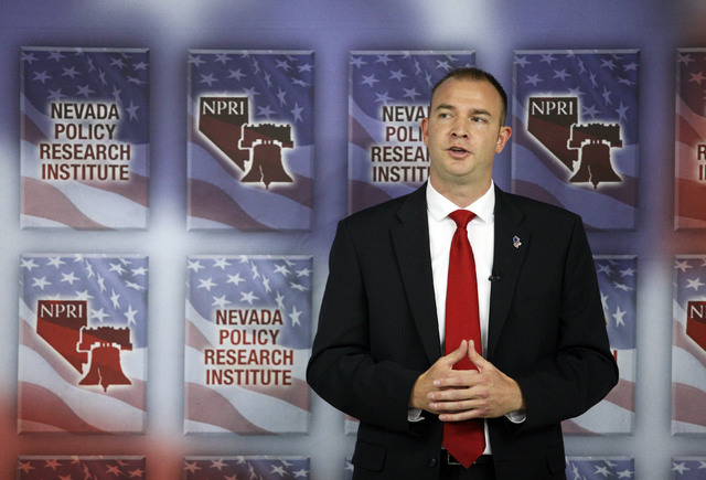Andy Mathews, president of Nevada Policy Research Institute, speaks near a domino demonstration during a news conference at Nevada Policy Research Institute Tuesday, July 22, 2014, in Las Vegas. ...