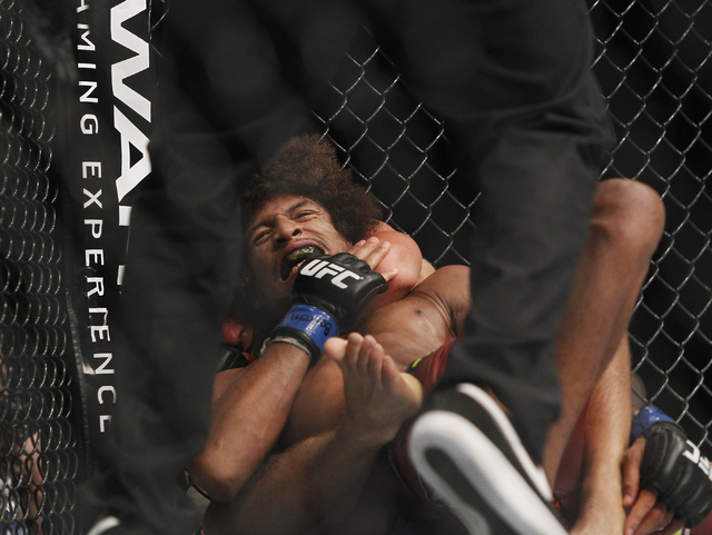 Urijah Faber gets Alex Caceres to tap out with a chock hold during UFC 175 at the Mandalay Bay Events Center in Las Vegas on Saturday, July 5, 2014. (Jason Bean/Las Vegas Review-Journal)