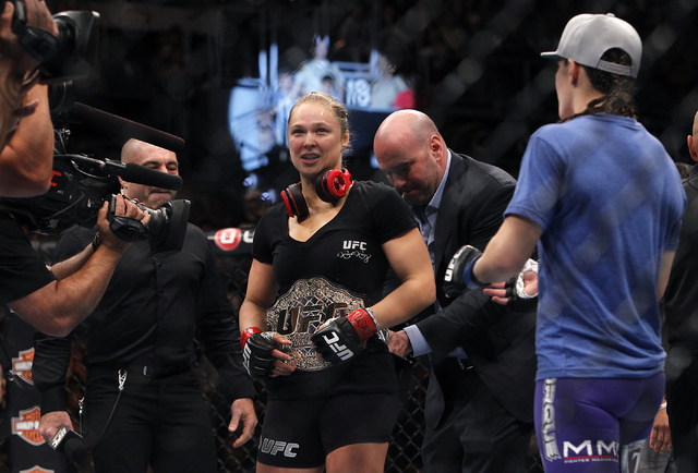 Dana White places the champion's belt on Ronda Rousey  after she defeated Alexis Davis in sixteen seconds during UFC 175 at the Mandalay Bay Events Center in Las Vegas on Saturday, July 5, 2014. ( ...