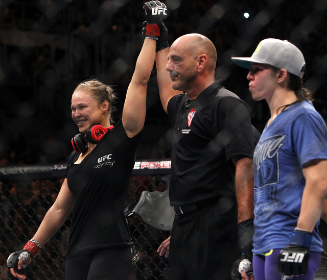 Ronda Rousey, left, raises her hand in victory over Alexis Davis during UFC 175 at the Mandalay Bay Events Center in Las Vegas on Saturday, July 5, 2014. (Jason Bean/Las Vegas Review-Journal)