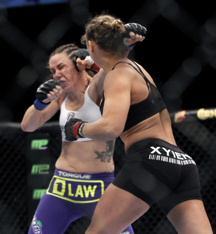 Ronda Rousey, right, hits Alexis Davis during UFC 175 at the Mandalay Bay Events Center in Las Vegas on Saturday, July 5, 2014. (Jason Bean/Las Vegas Review-Journal)